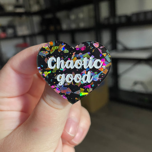 Broche "Chaotic good" en acrylique noire avec des éclats de confettis multicolores