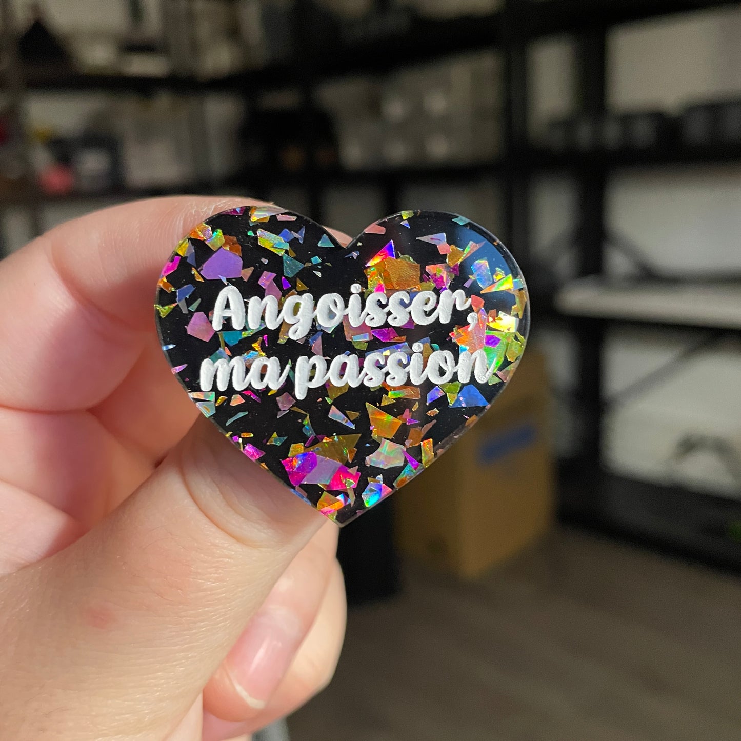Broche "Angoisser, ma passion" en acrylique noire avec des éclats de confettis multicolores