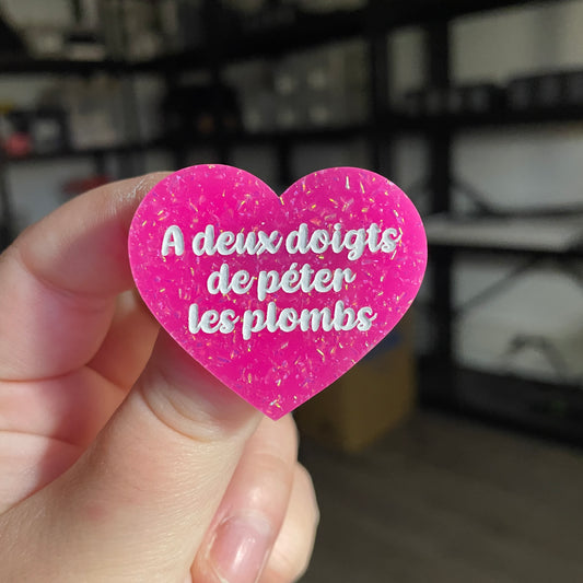 Broche "A deux doigts de péter les plombs" en acrylique rose à paillettes