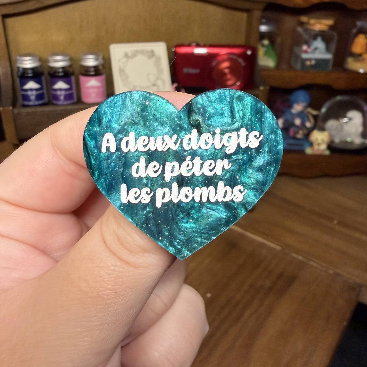 Broche "A deux doigts de péter les plombs" en acrylique marbrée verte et noire à paillettes