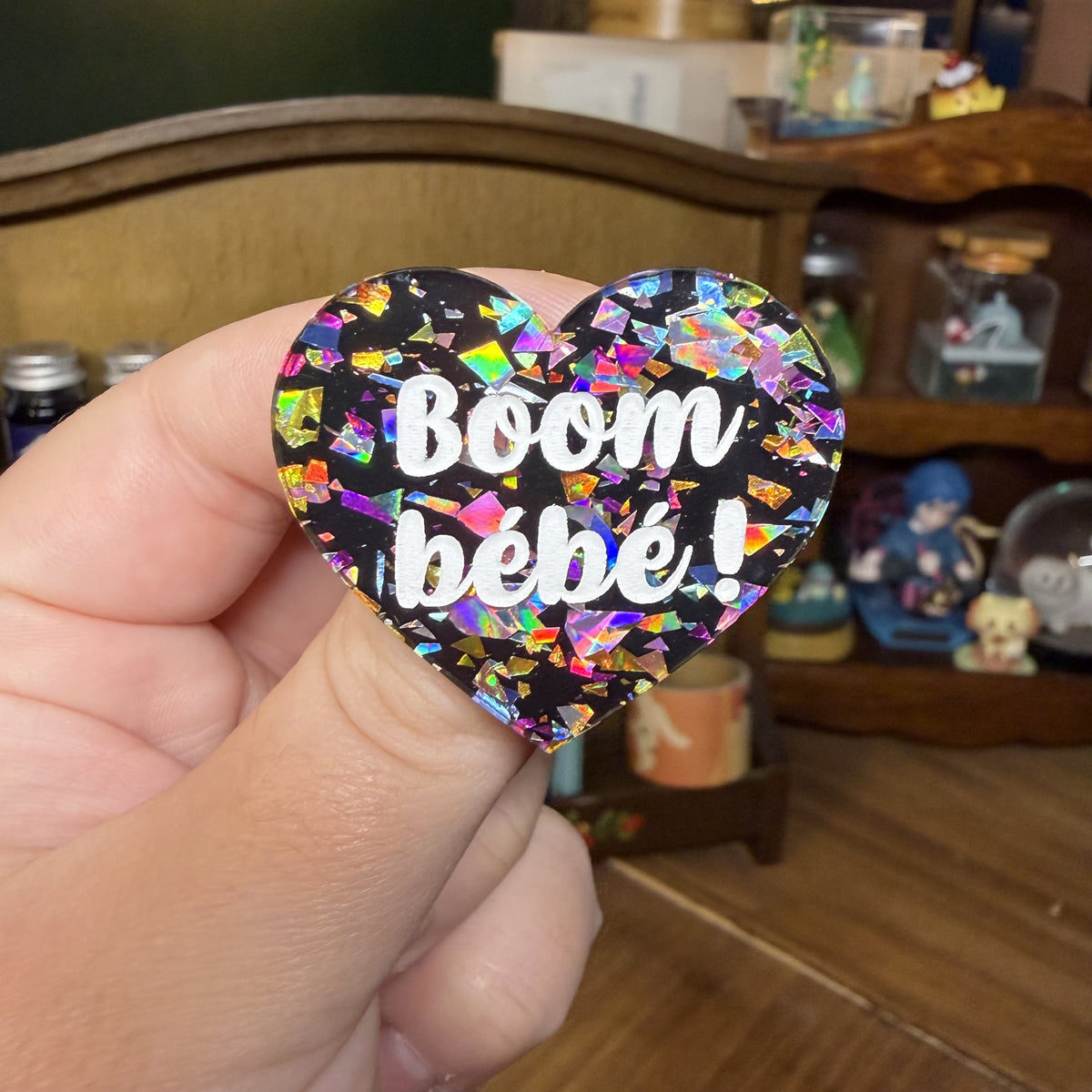 Broche "Boom bébé !" en acrylique noire avec des éclats de confettis multicolores