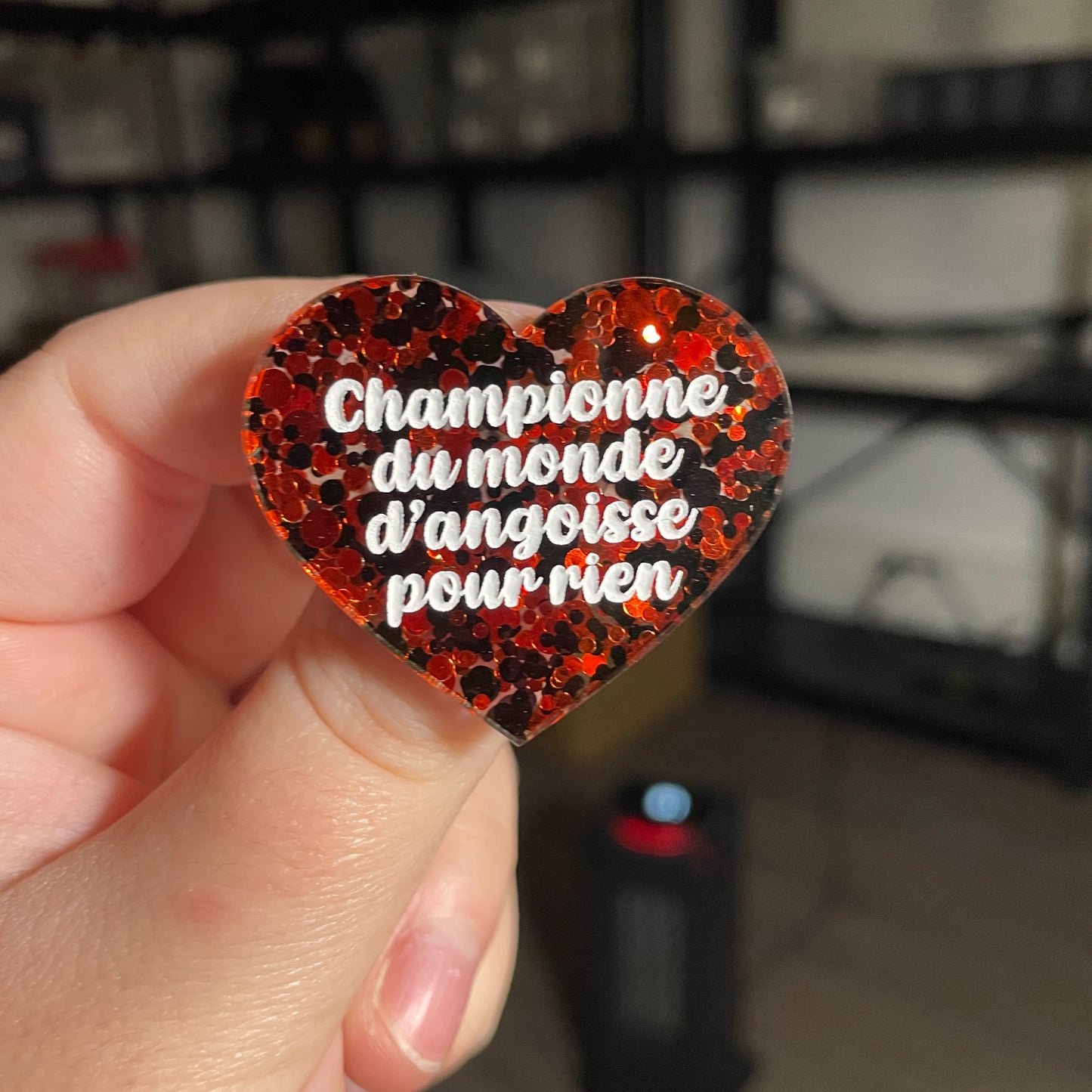 Broche "Championne du monde d'angoisse pour rien" en acrylique semi transparente avec des pois rouges et noirs