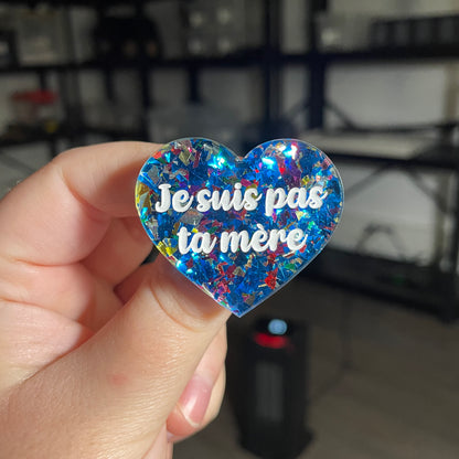 Broche "Je suis pas ta mère" en acrylique transparente avec des confettis bleus et multicolores