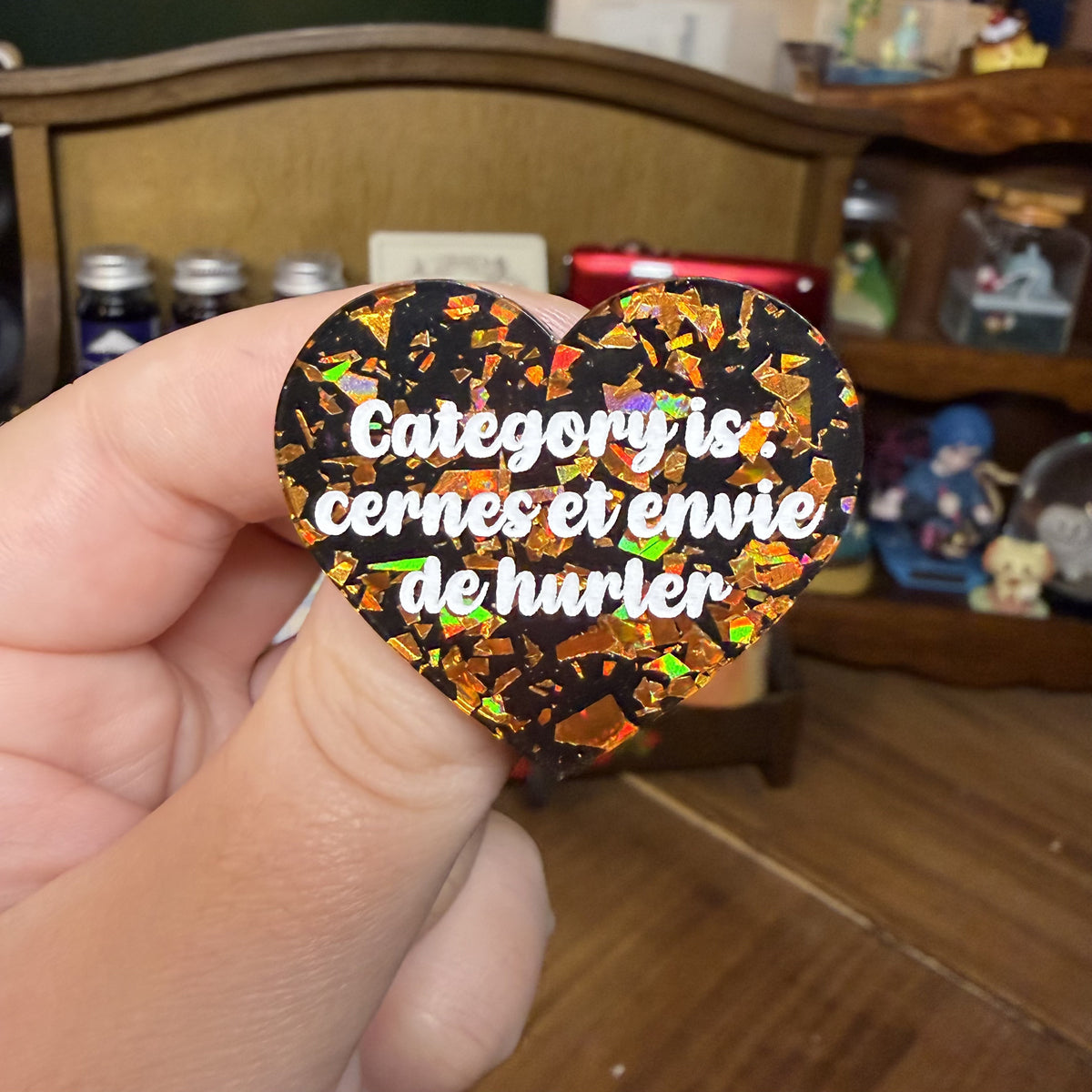 Broche "Category is : cernes et envie de hurler" en acrylique noire avec des éclats de confettis oranges