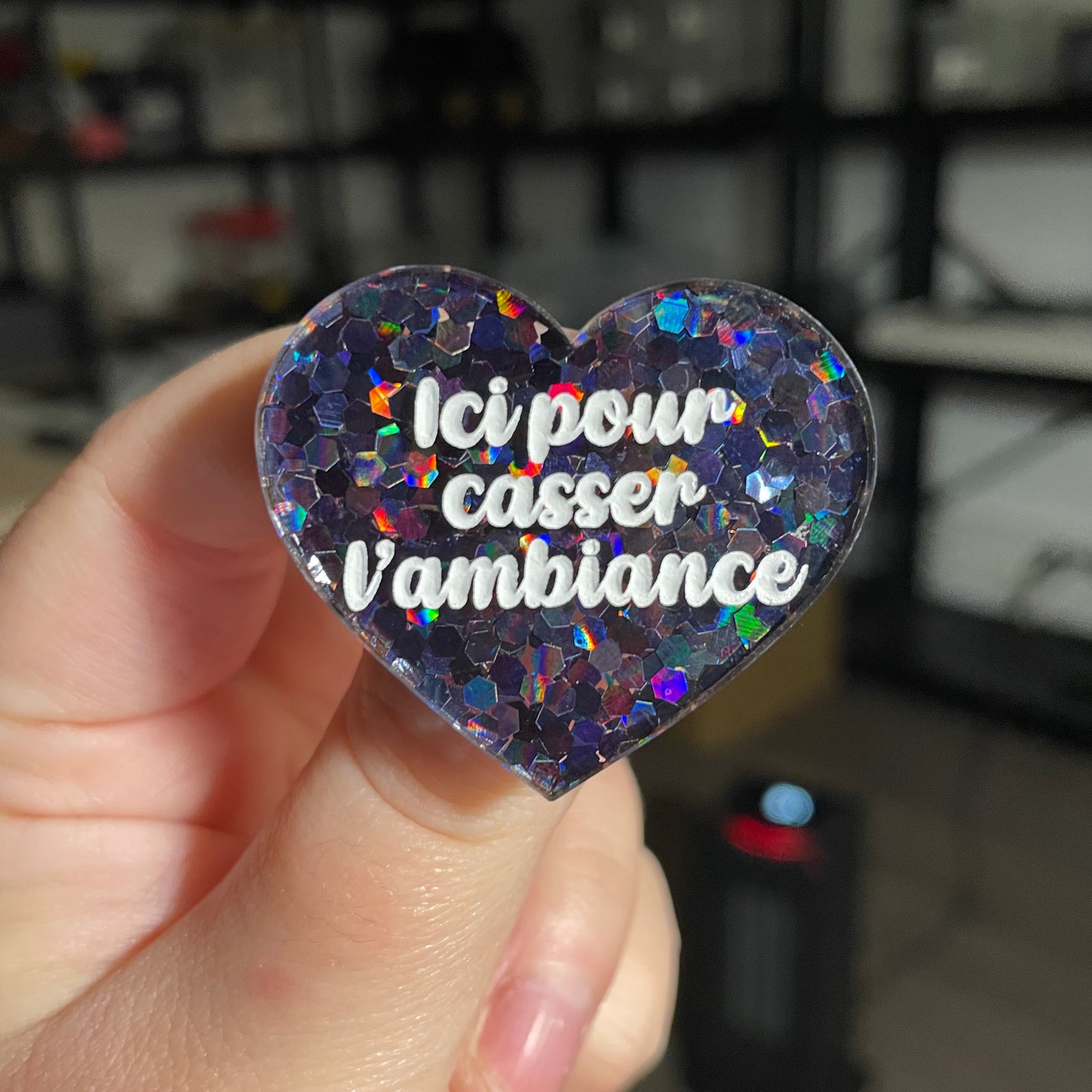 Broche "Ici pour casser l'ambiance" en acrylique semi transparente avec des confettis noirs