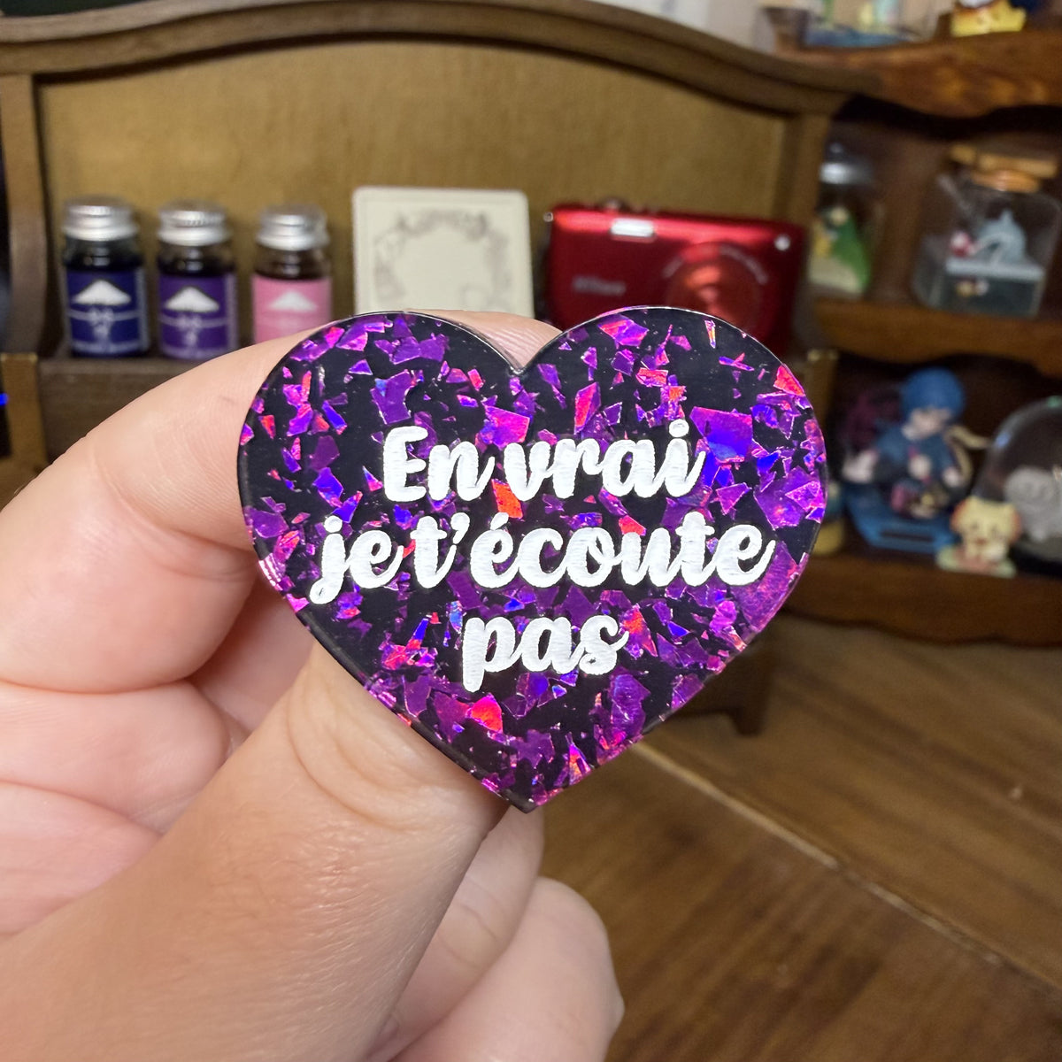 Broche "En vrai je t'écoute pas" en acrylique noire avec des éclats de confettis violets