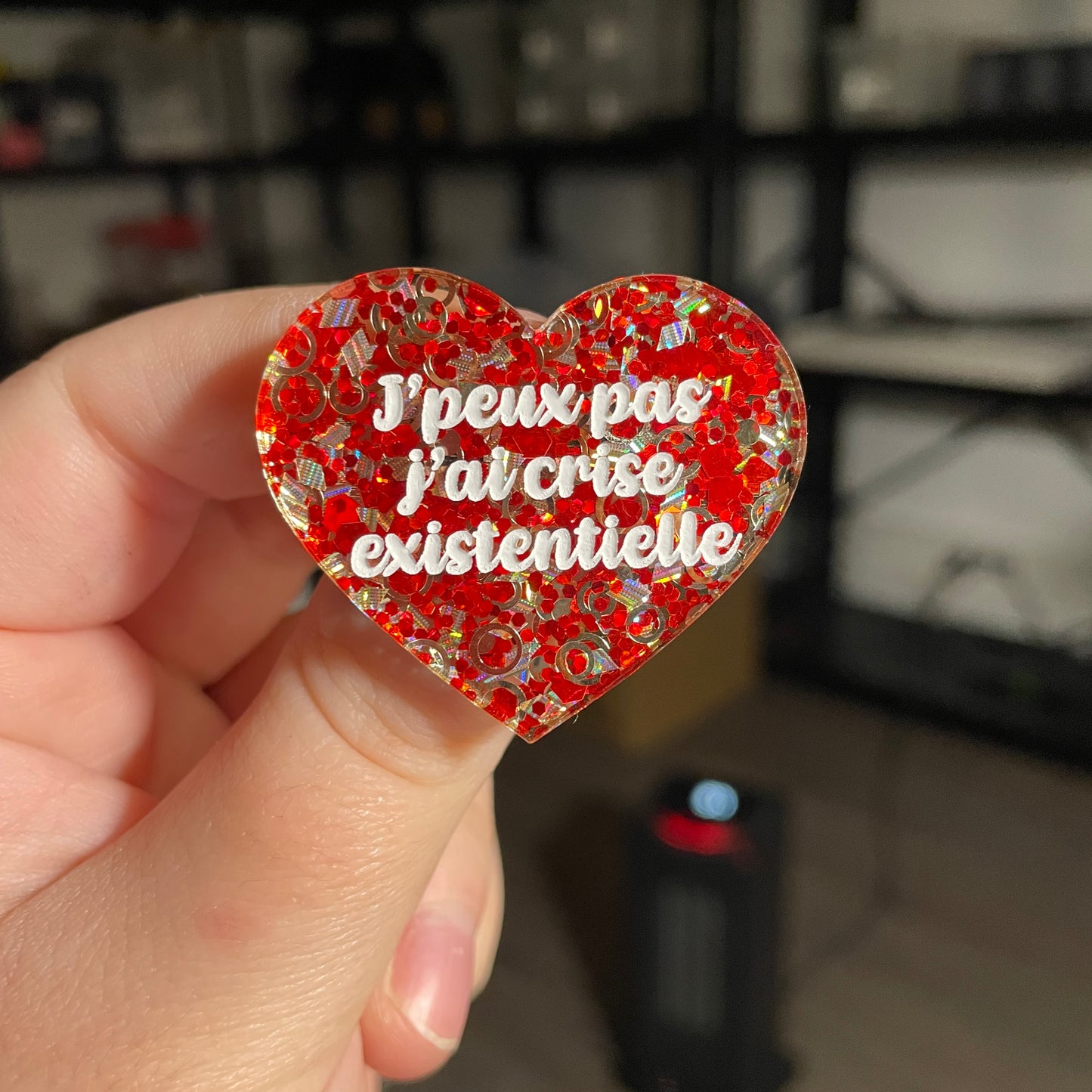 Broche "J'peux pas j'ai crise existentielle" en acrylique semi transparente avec des confettis rouges et argentés