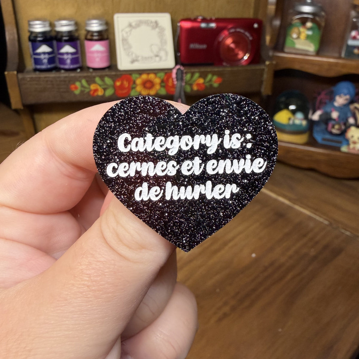 Broche "Category is : cernes et envie de hurler" en acrylique noire à paillettes