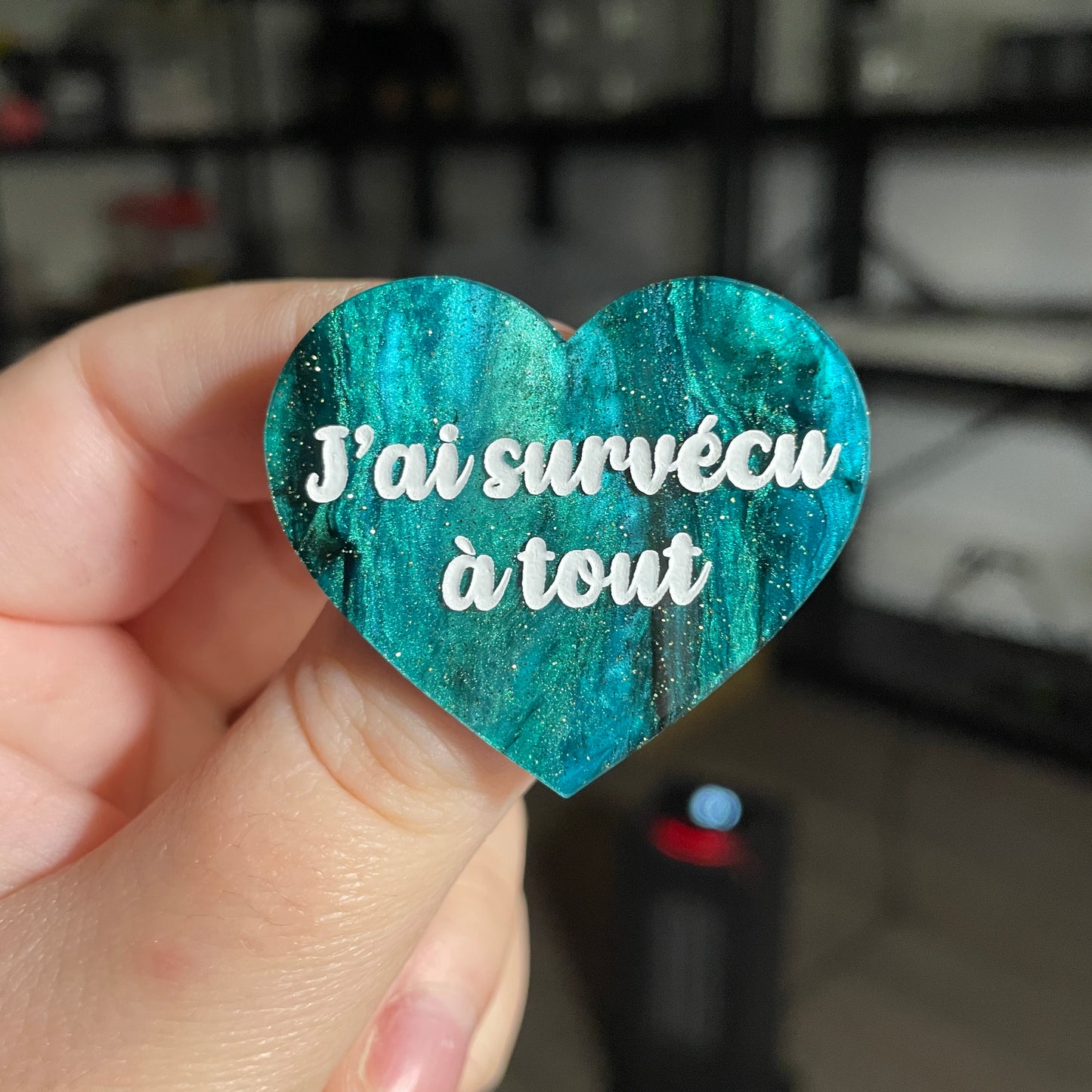 Broche "J'ai survécu à tout" en acrylique marbrée verte et noire à paillettes