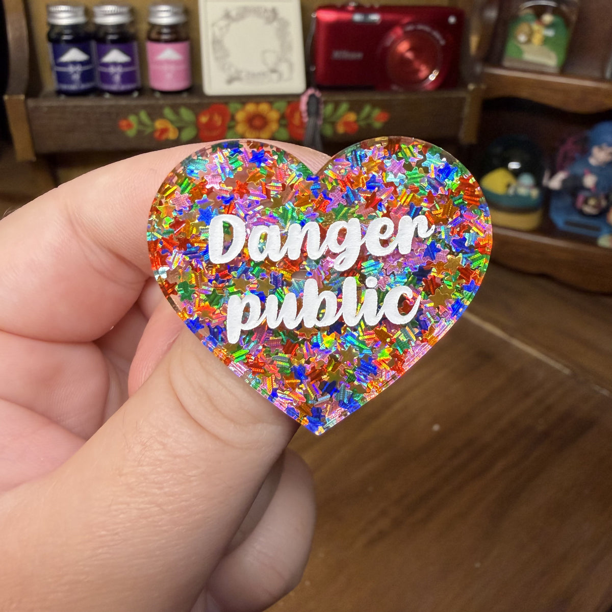 Broche "Danger public" en acrylique semi transparente avec des étoiles multicolores