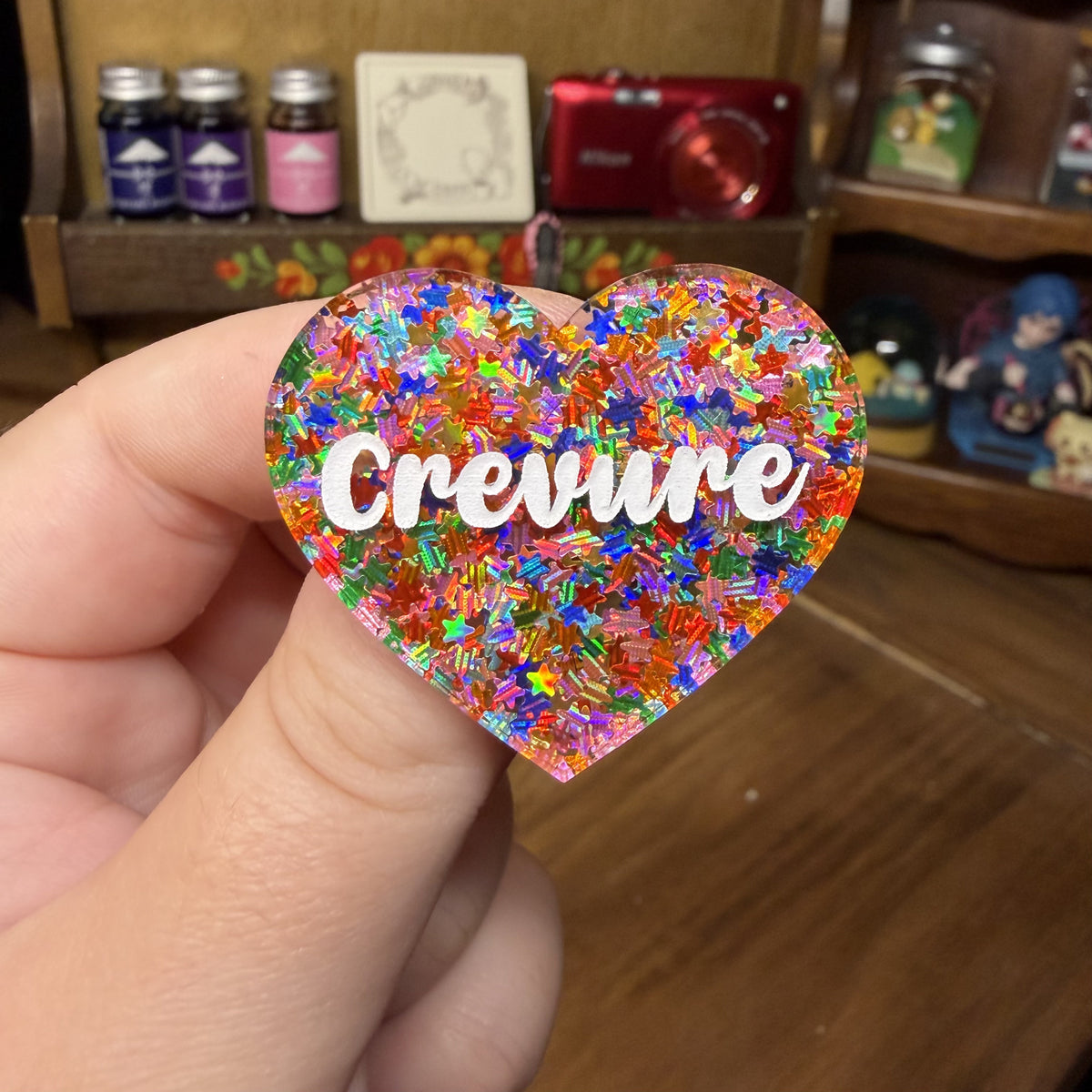 Broche "Crevure" en acrylique semi transparente avec des étoiles multicolores