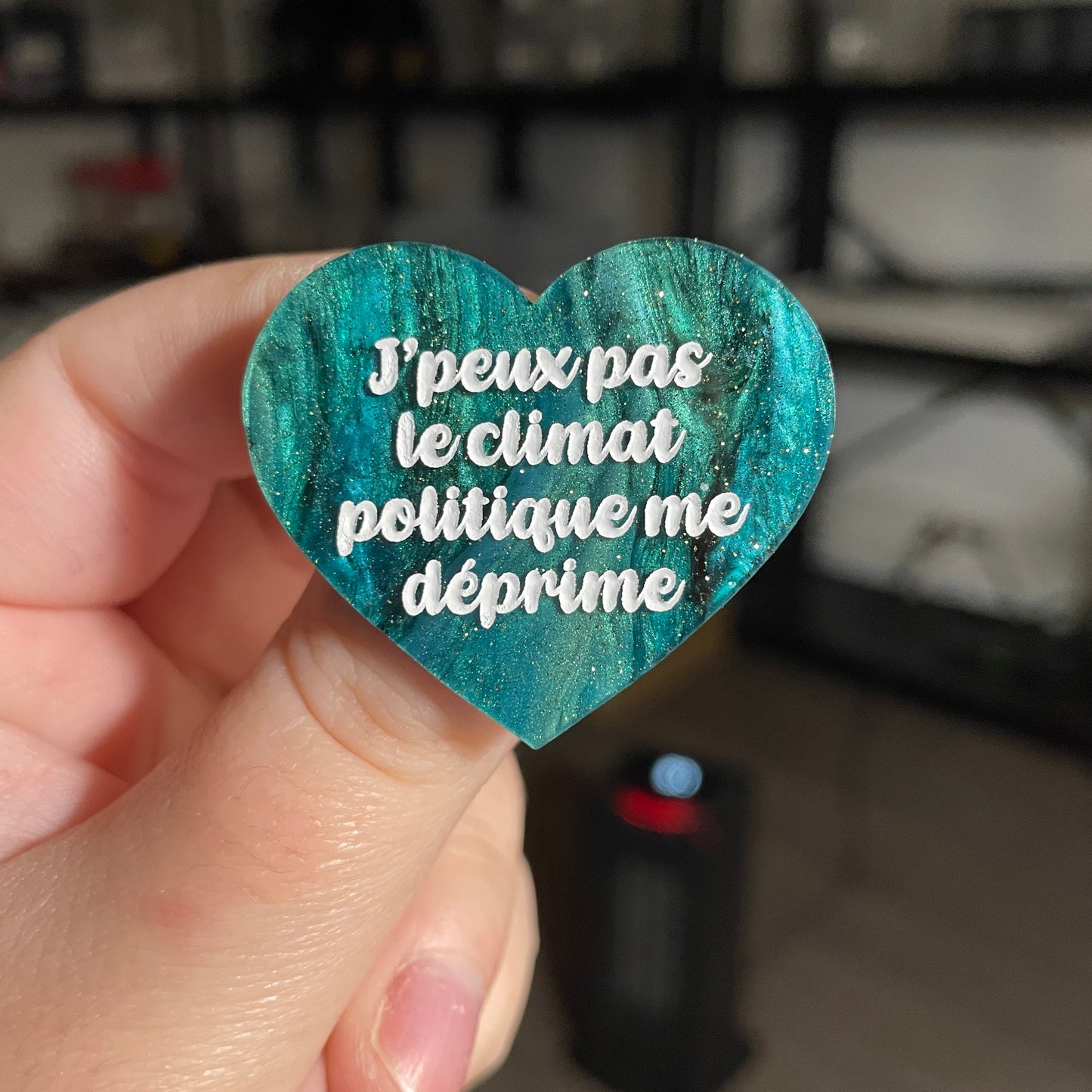 Broche "J'peux pas le climat politique me déprime" en acrylique marbrée verte et noire à paillettes
