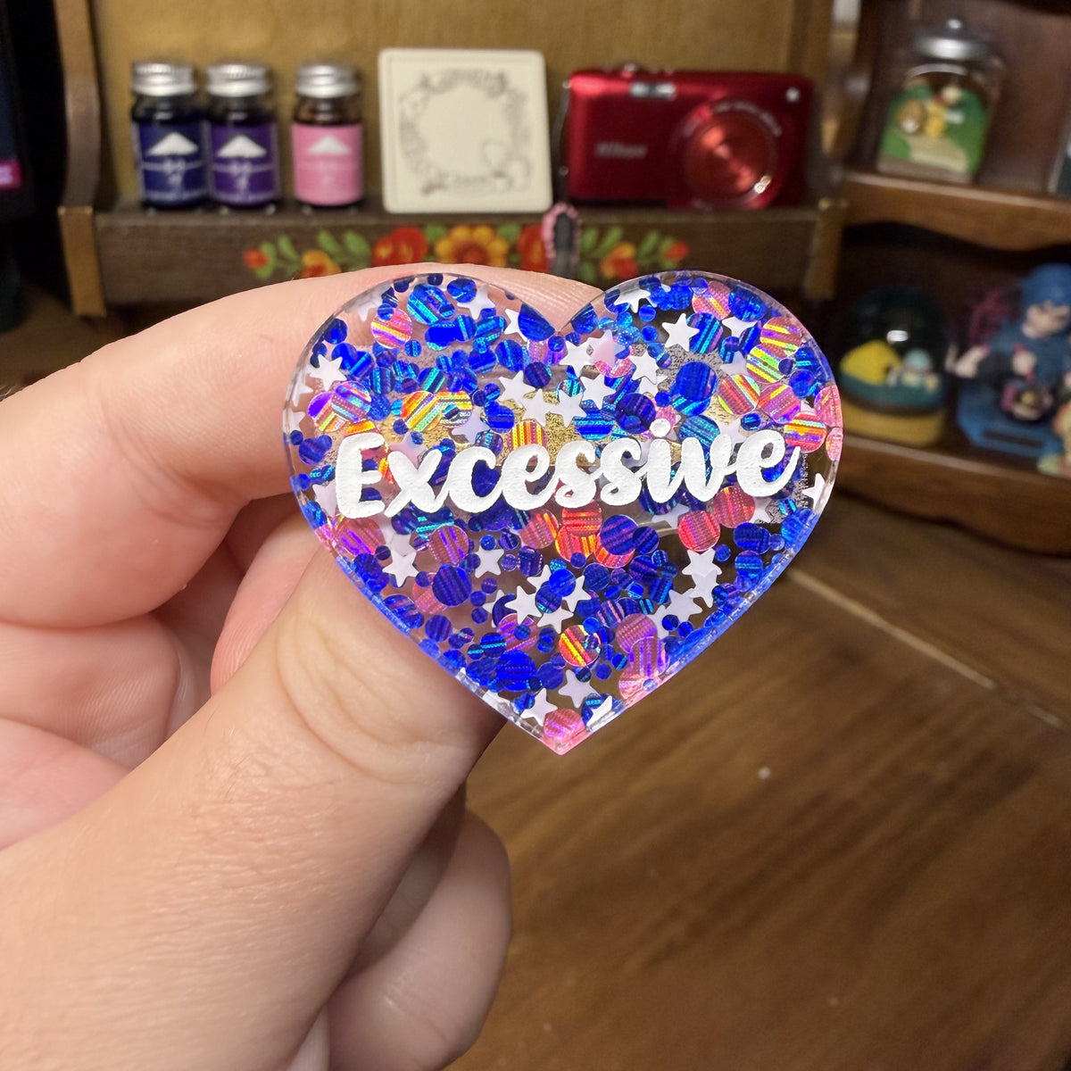 Broche "Excessive" en acrylique semi transparente avec des confettis bleus, roses et blancs