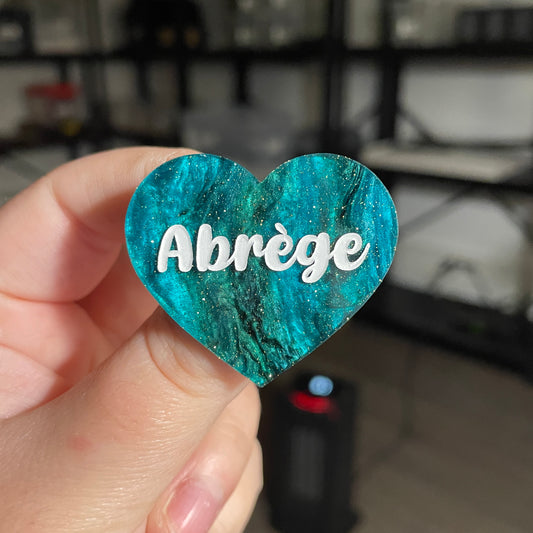 Broche "Abrège" en acrylique marbrée verte et noire à paillettes