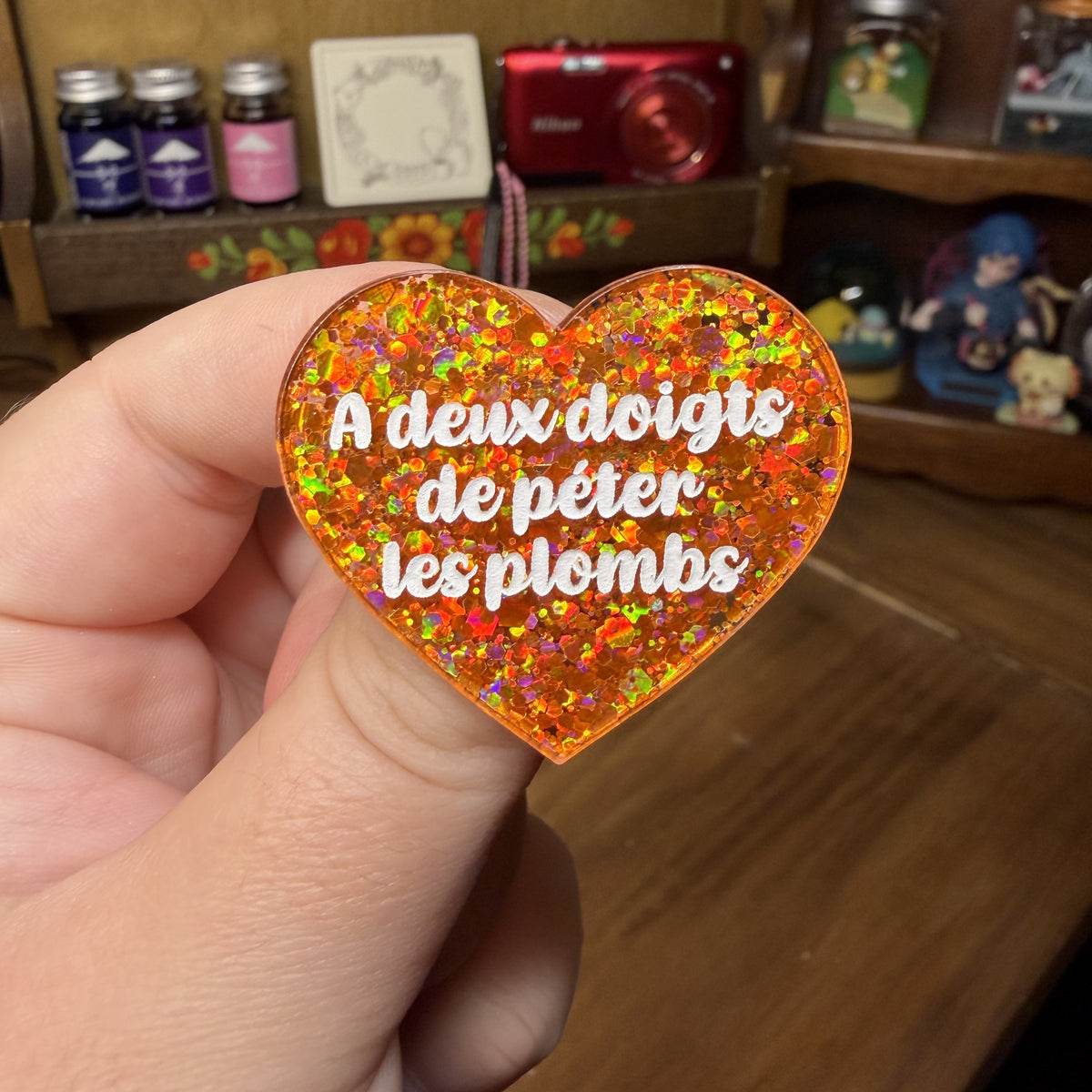 [Contrôle technique] Broche "A deux doigts de péter les ploms" en acrylique semi transparente avec des paillettes oranges