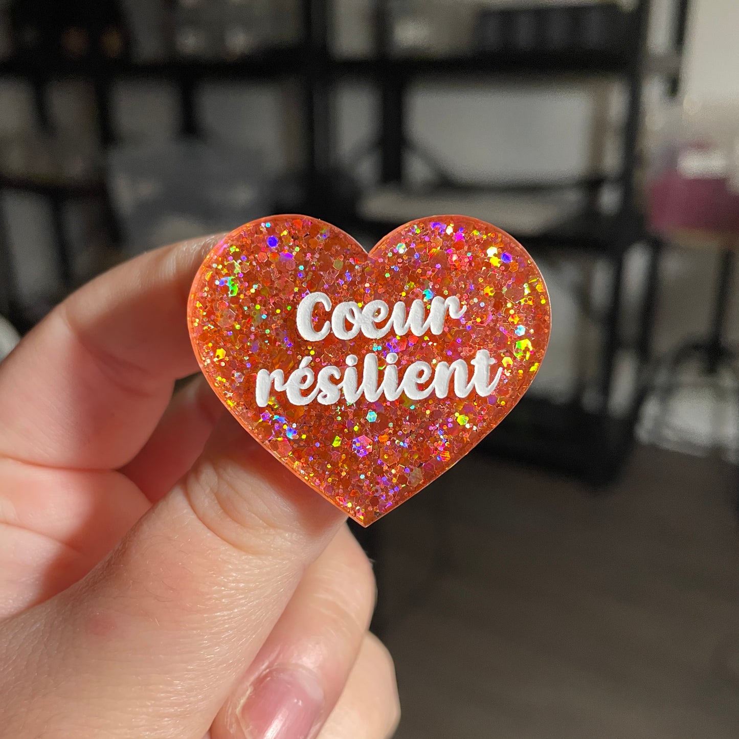 Broche "Coeur résilient" en acrylique semi transparente avec des paillettes corail