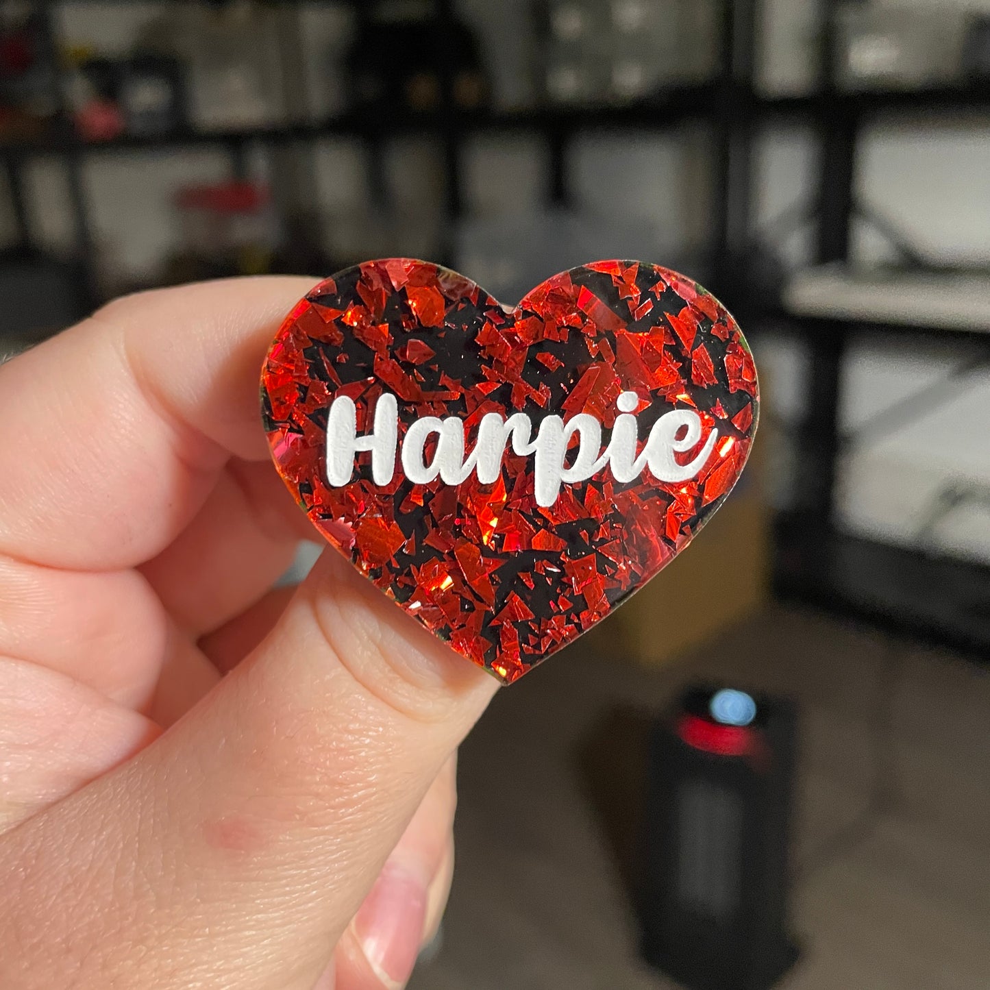 Broche "Harpie" en acrylique noire avec des éclats de confettis rouges