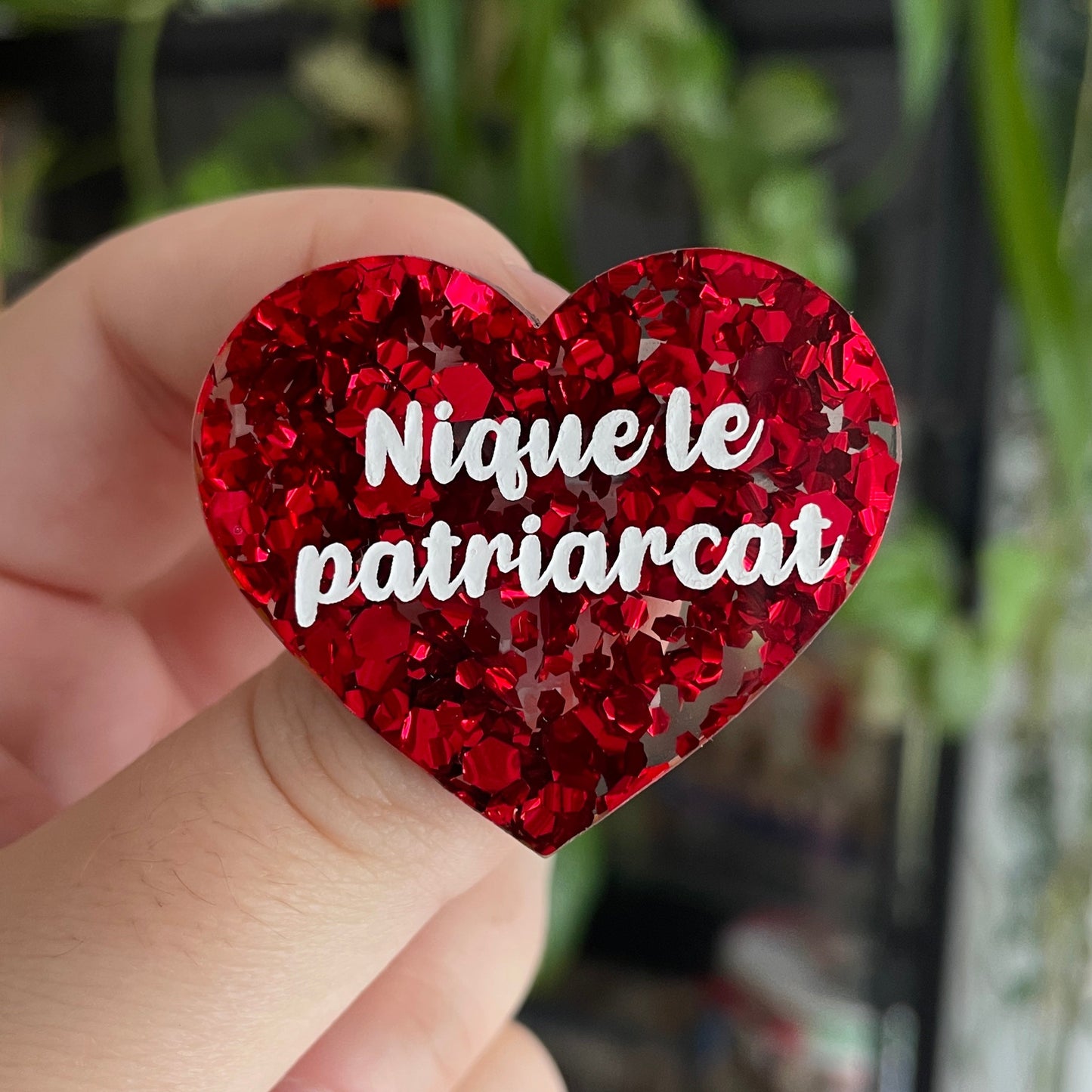 Broche "Nique le patriarcat" en acrylique semi-transparente avec des confettis rouges