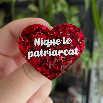 Broche "Nique le patriarcat" en acrylique semi-transparente avec des confettis rouges