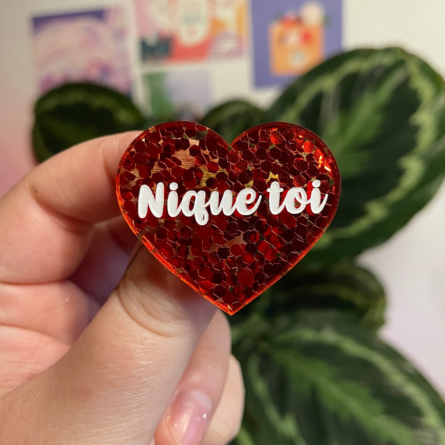 Broche "Nique toi" en acrylique semi transparente avec des confettis rouges
