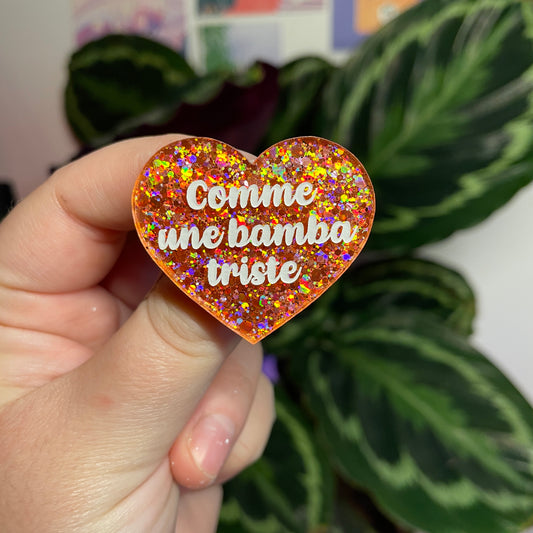 Broche "Comme une bamba triste" en acrylique semi transparente avec des paillettes corail
