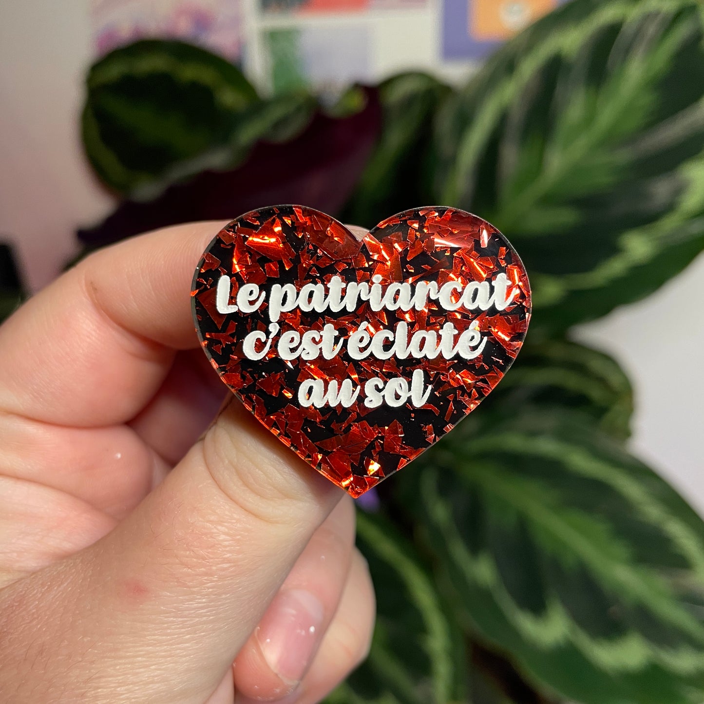 Broche "Le patriarcat c'est éclaté au sol" en acrylique noire avec des éclats de confettis rouges