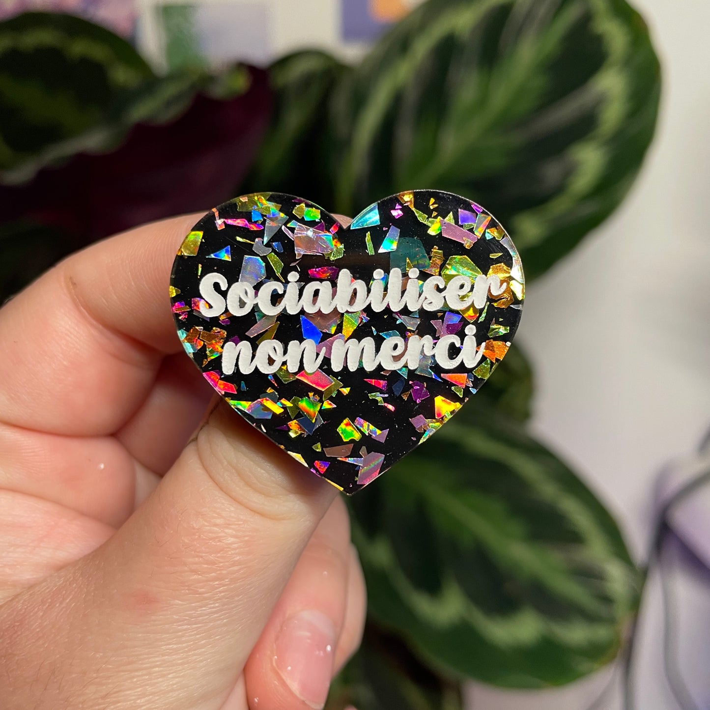 Broche "Sociabiliser non merci" en acrylique noire avec des éclats de confettis multicolores