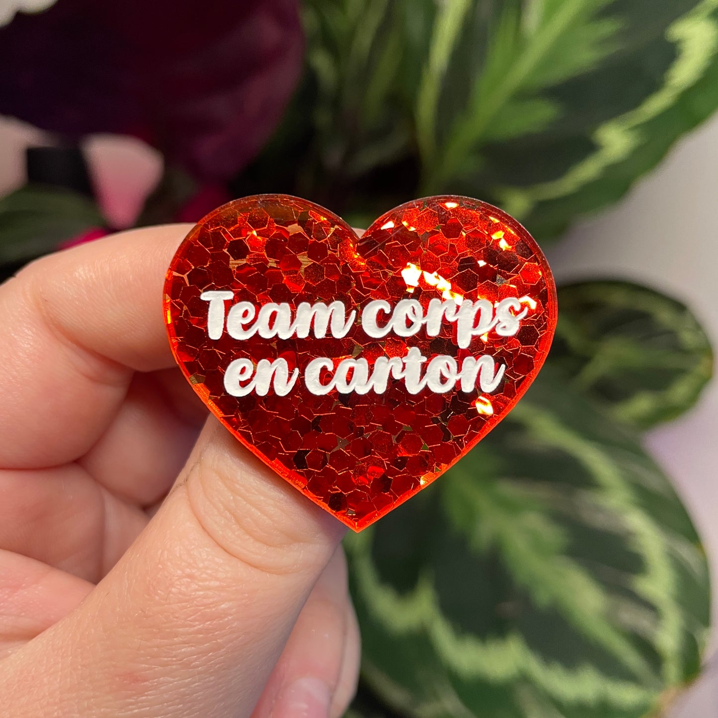Broche "Team corps en carton" en acrylique semi transparente avec des confettis rouges