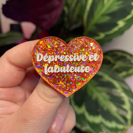 Broche "Dépressive et fabuleuse" en acrylique semi transparente avec des paillettes corail