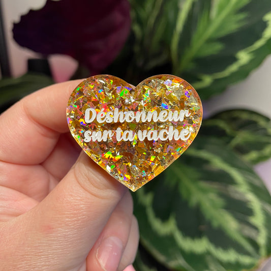 Broche "Déshonneur sur ta vache" en acrylique transparente avec des confettis jaunes