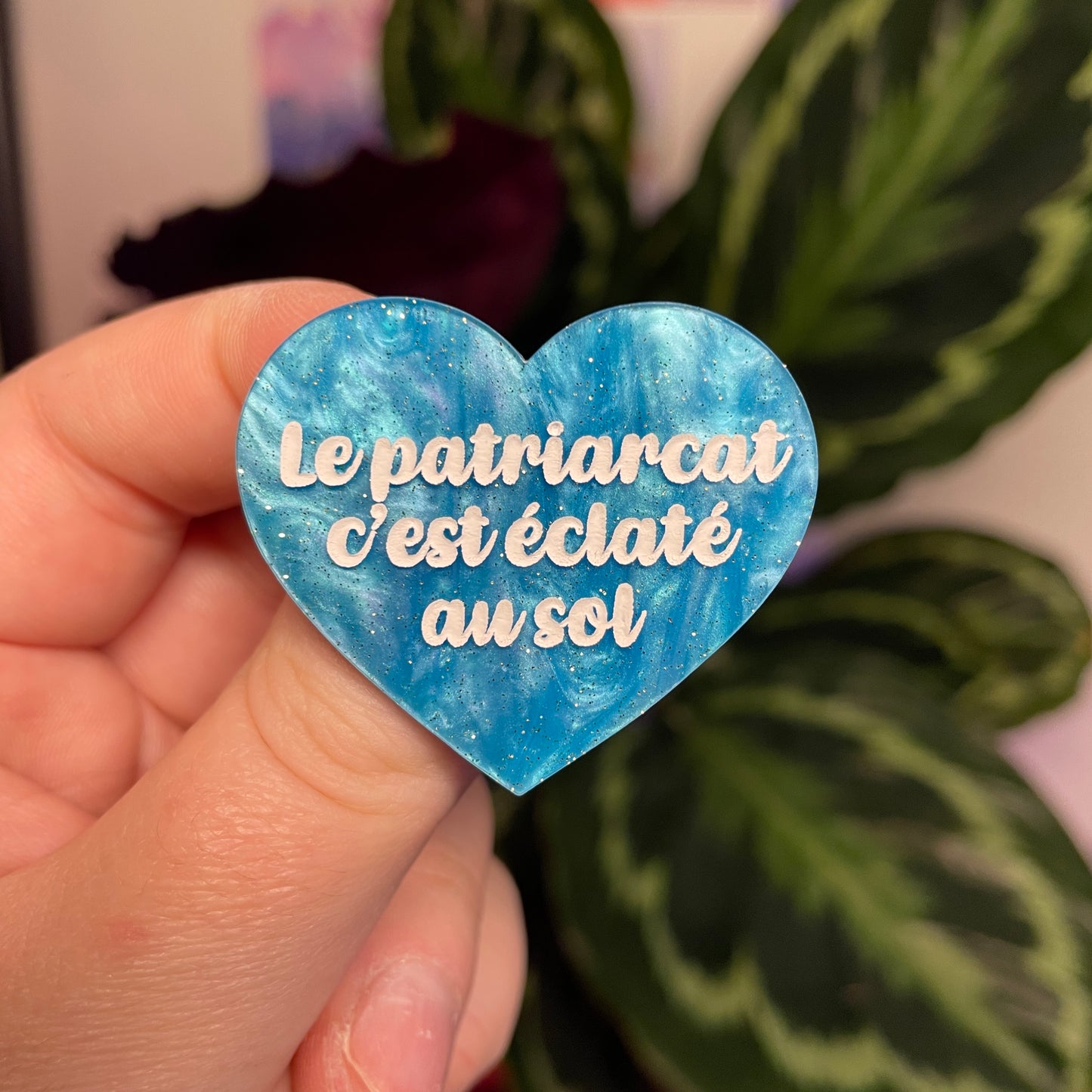 Broche "Le patriarcat c'est éclaté au sol" en acrylique marbrée bleue à paillettes