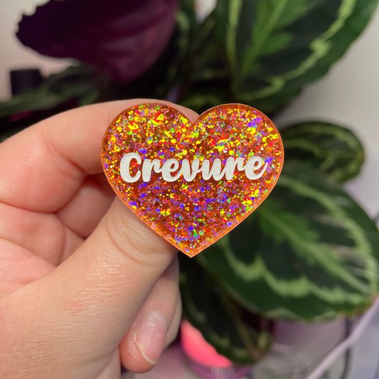 Broche "Crevure" en acrylique semi transparente avec des paillettes corail