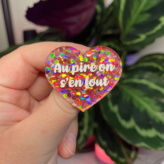 Broche "Au pire on s'en fout" en acrylique semi transparente avec des confettis corail