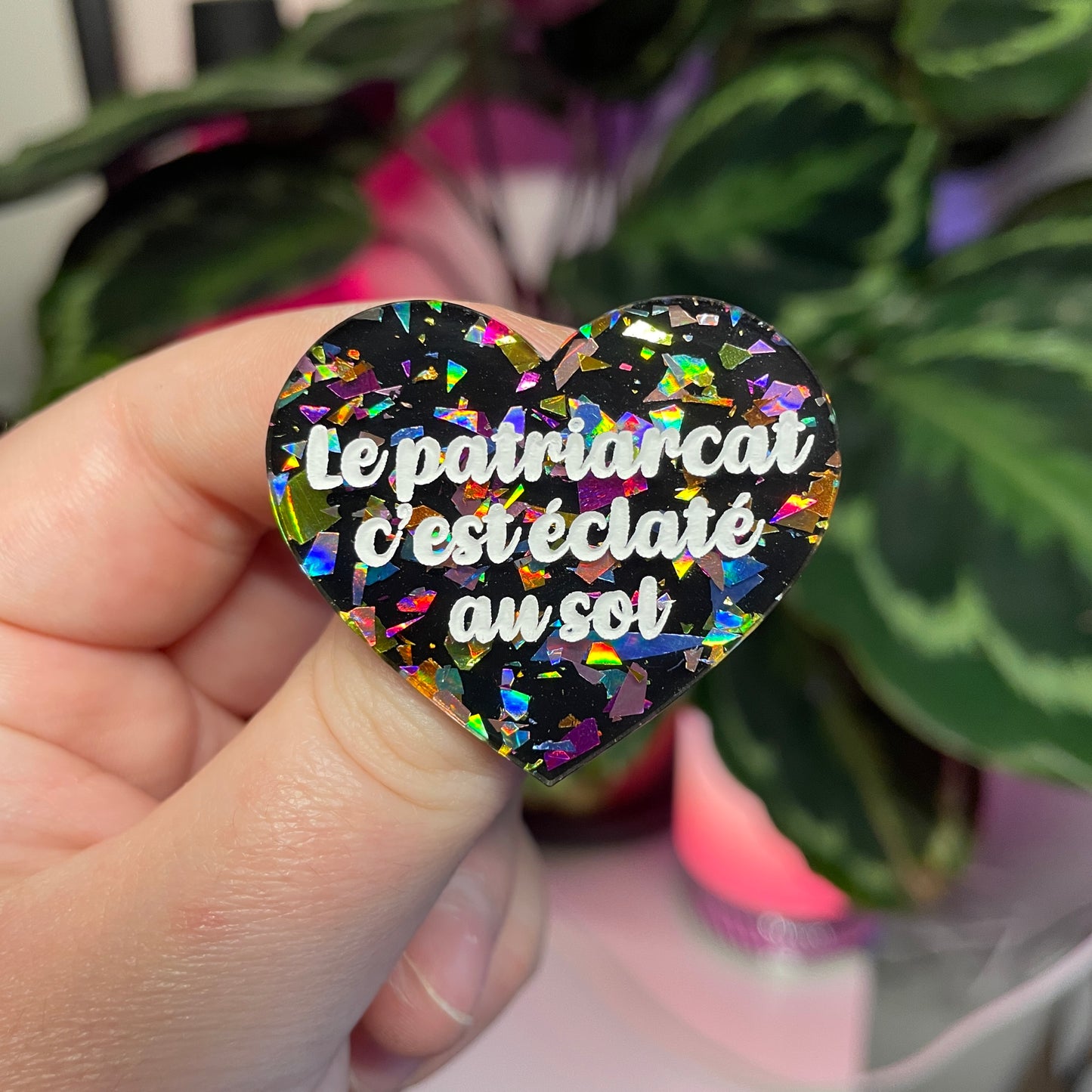 Broche "Le patriarcat c'est éclaté au sol" en acrylique noire avec des éclats de confettis multicolores