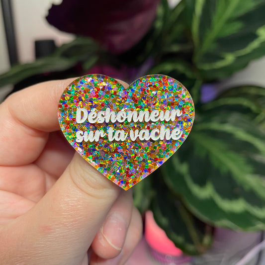 Broche "Déshonneur sur ta vache" en acrylique semi transparente avec des pois multicolores