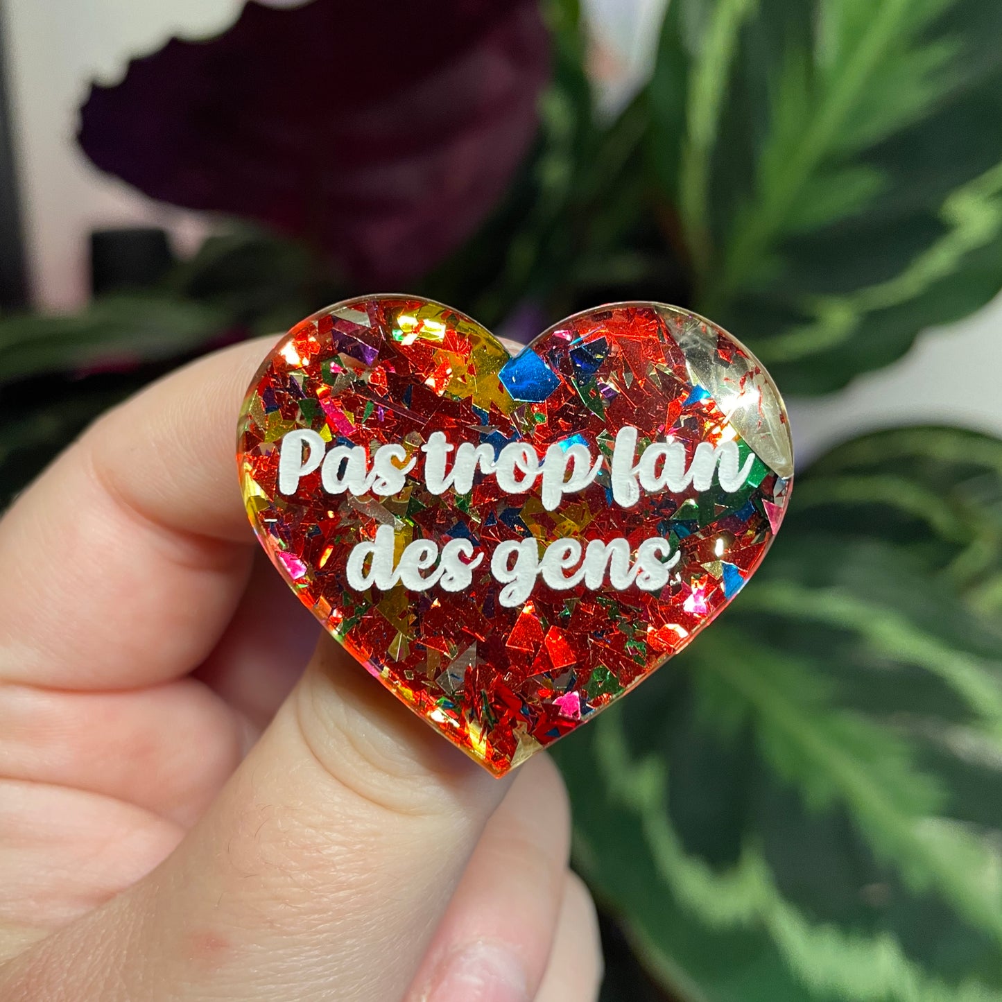 Broche "Pas trop fan des gens" en acrylique transparente avec des confettis rouges et multicolores