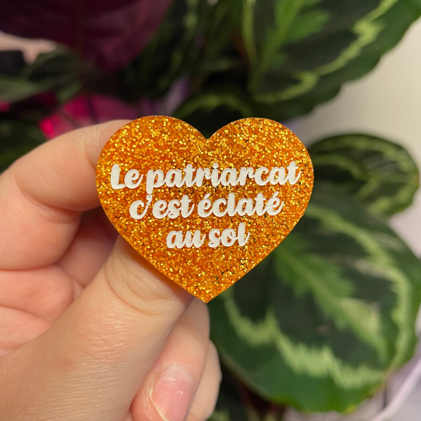 Broche "Le patriarcat c'est éclaté au sol" en acrylique à paillettes oranges