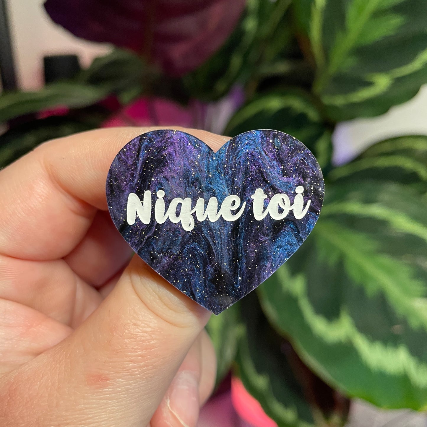 Broche "Nique toi" en acrylique marbrée bleue, noire et violette à paillettes