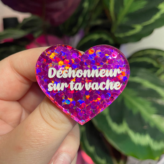 Broche "Déshonneur sur ta vache" en acrylique semi transparente avec des confettis fuchsia