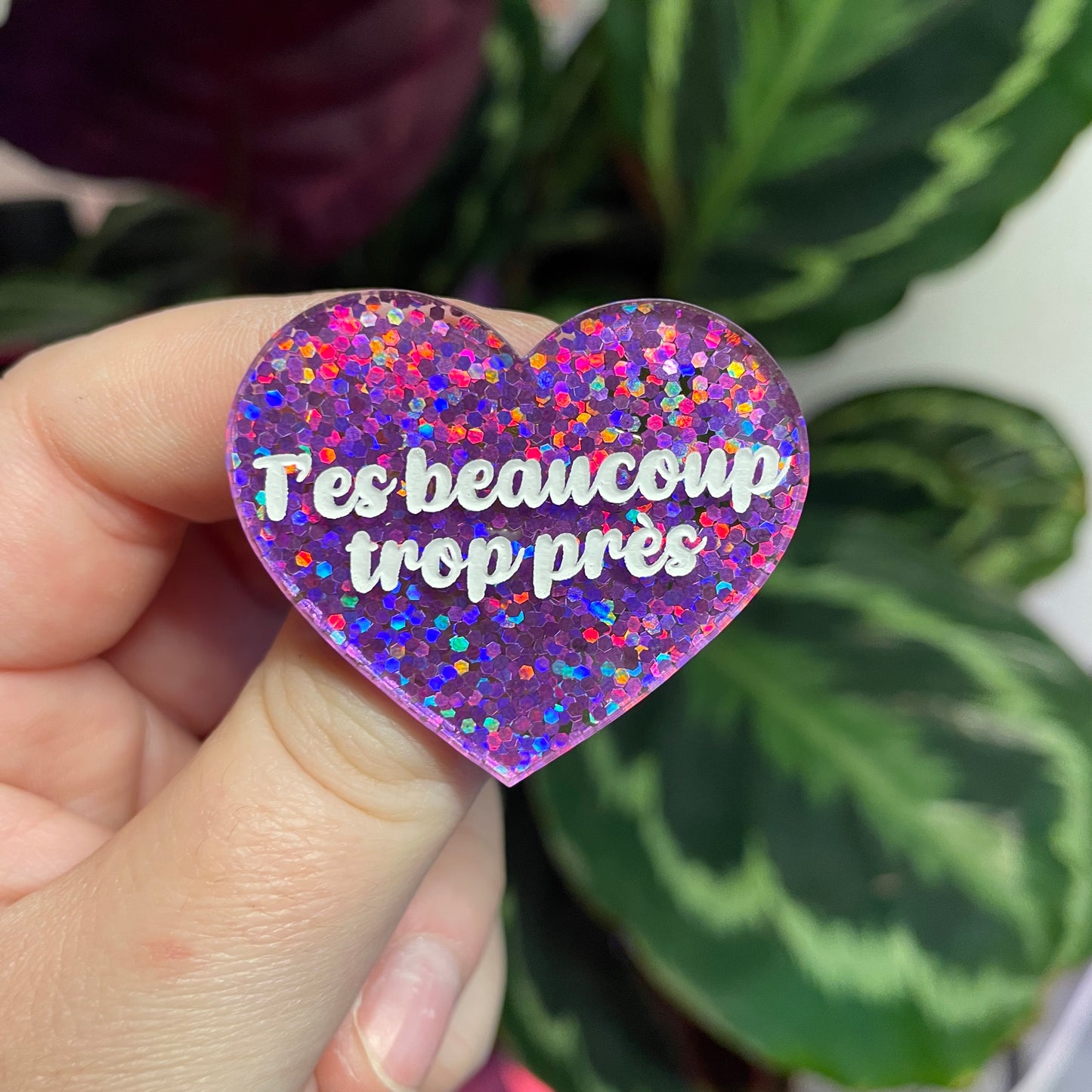 Broche "T'es beaucoup trop près" en acrylique semi transparente avec des confettis violets
