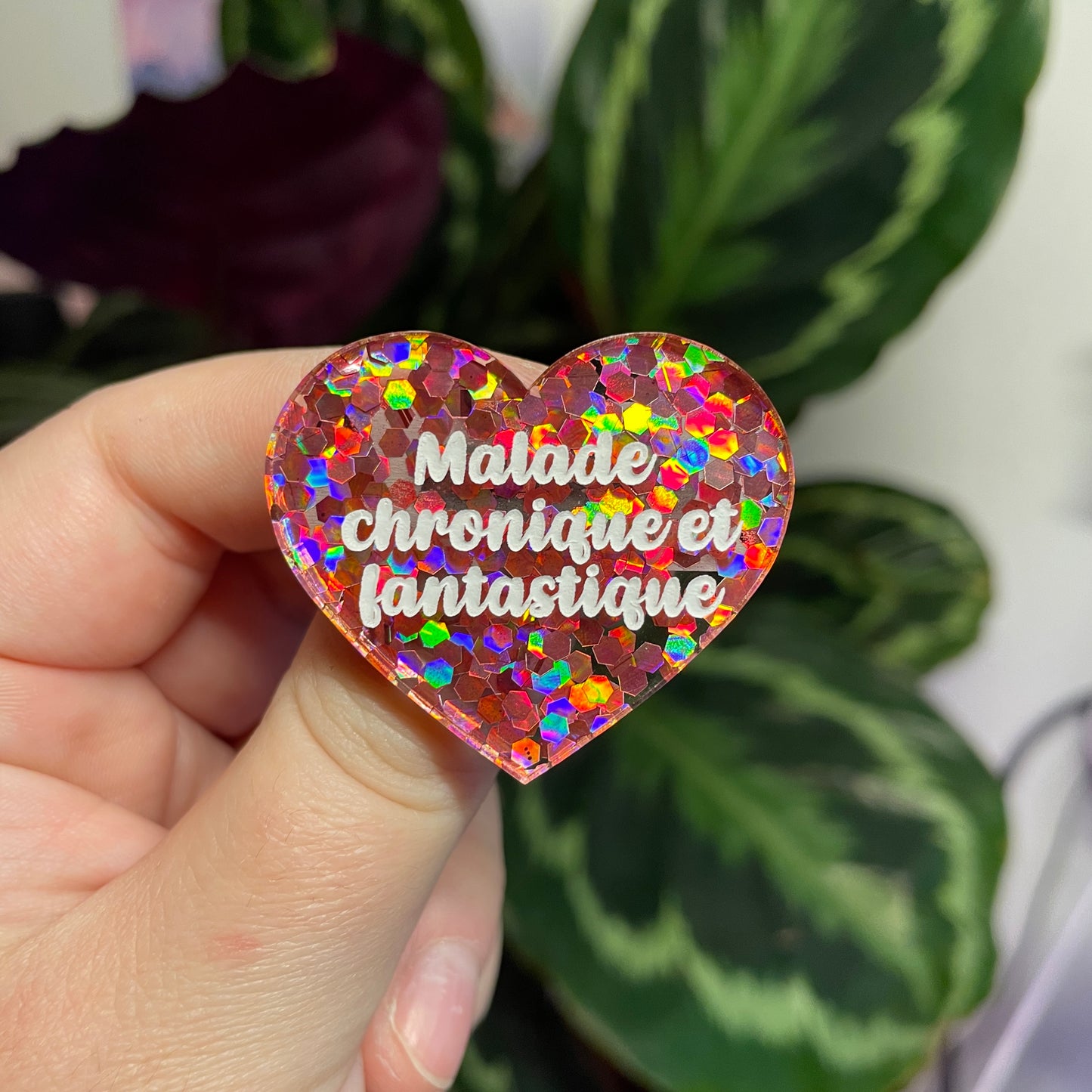 Broche "Malade chronique et fantastique" en acrylique semi transparente avec des confettis corail