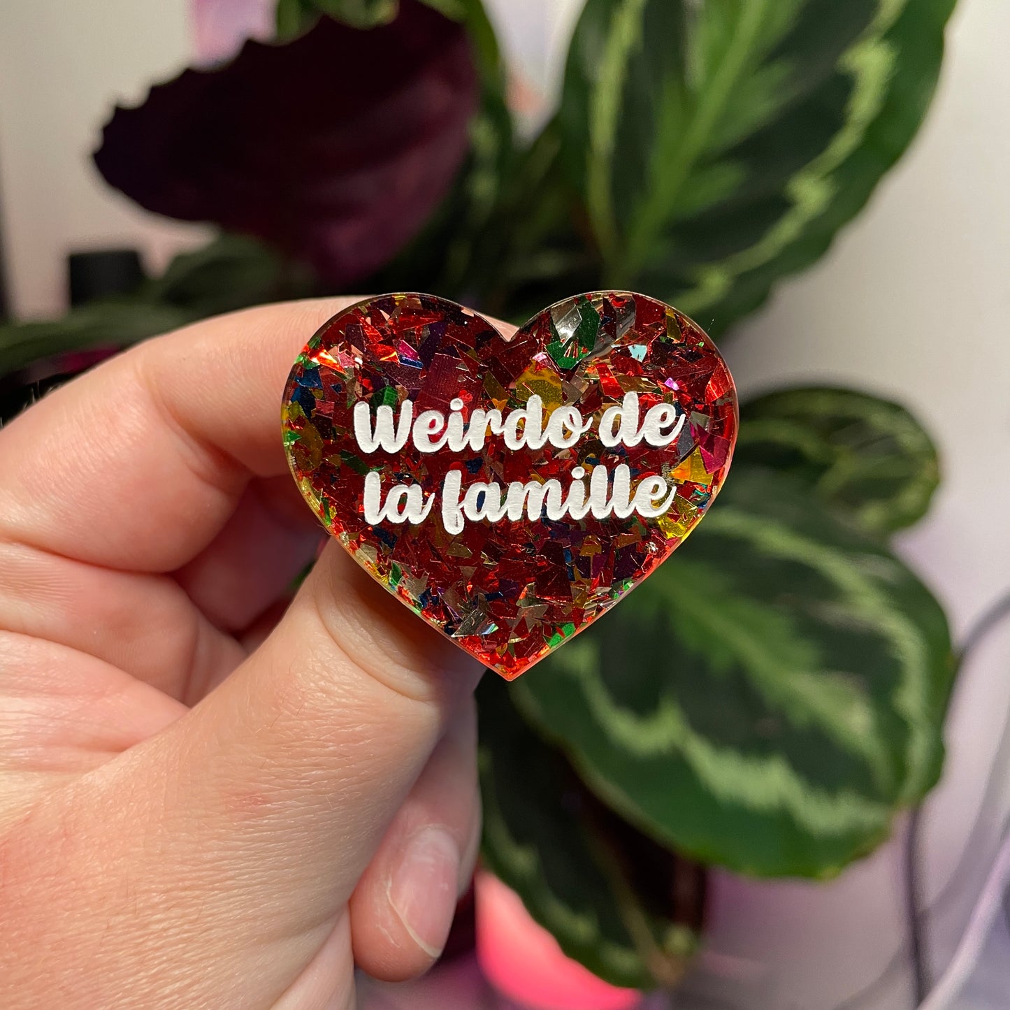 Broche "Weirdo de la famille" en acrylique transparente avec des confettis rouges et multicolores