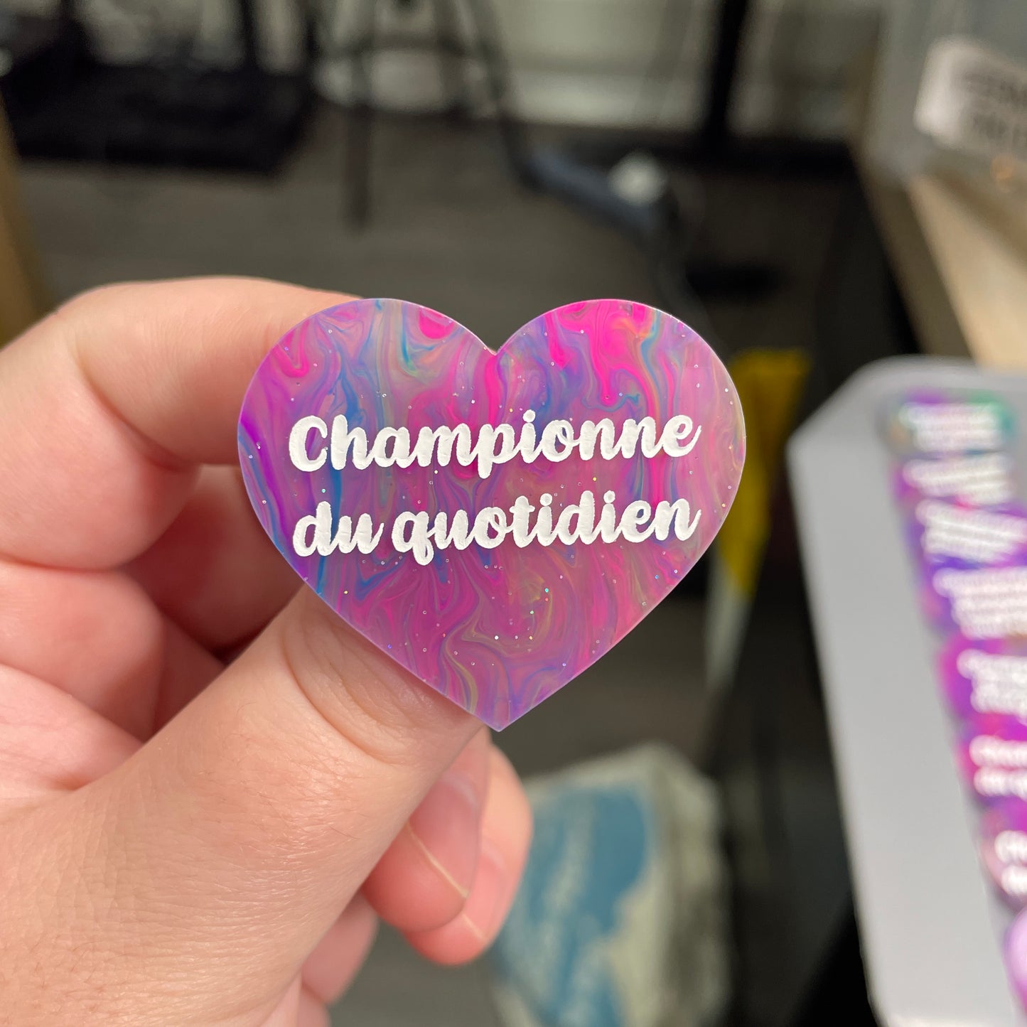 Broche "Championne du quotidien" en acrylique semi-transparente marbrée multicolore