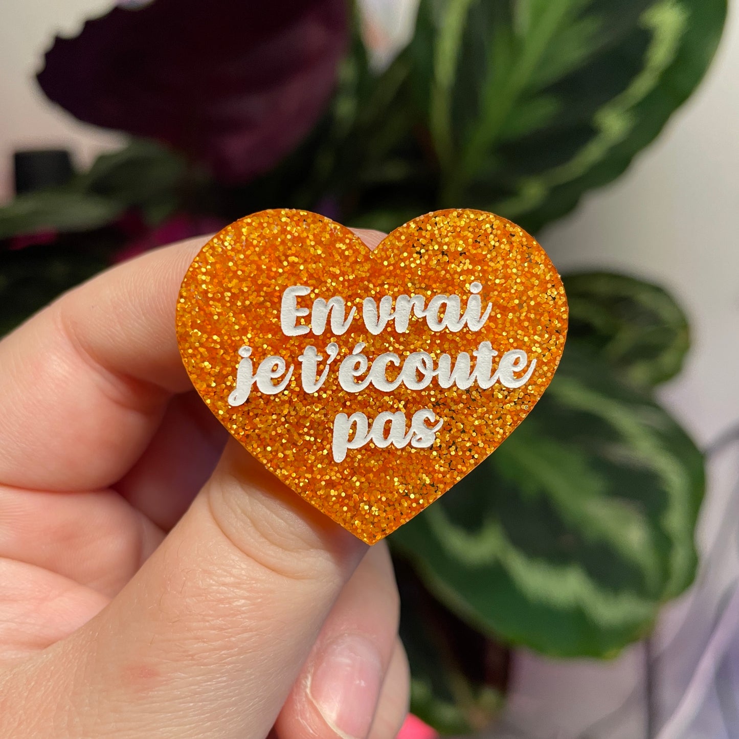 Broche "En vrai je t'écoute pas" en acrylique orange à paillettes