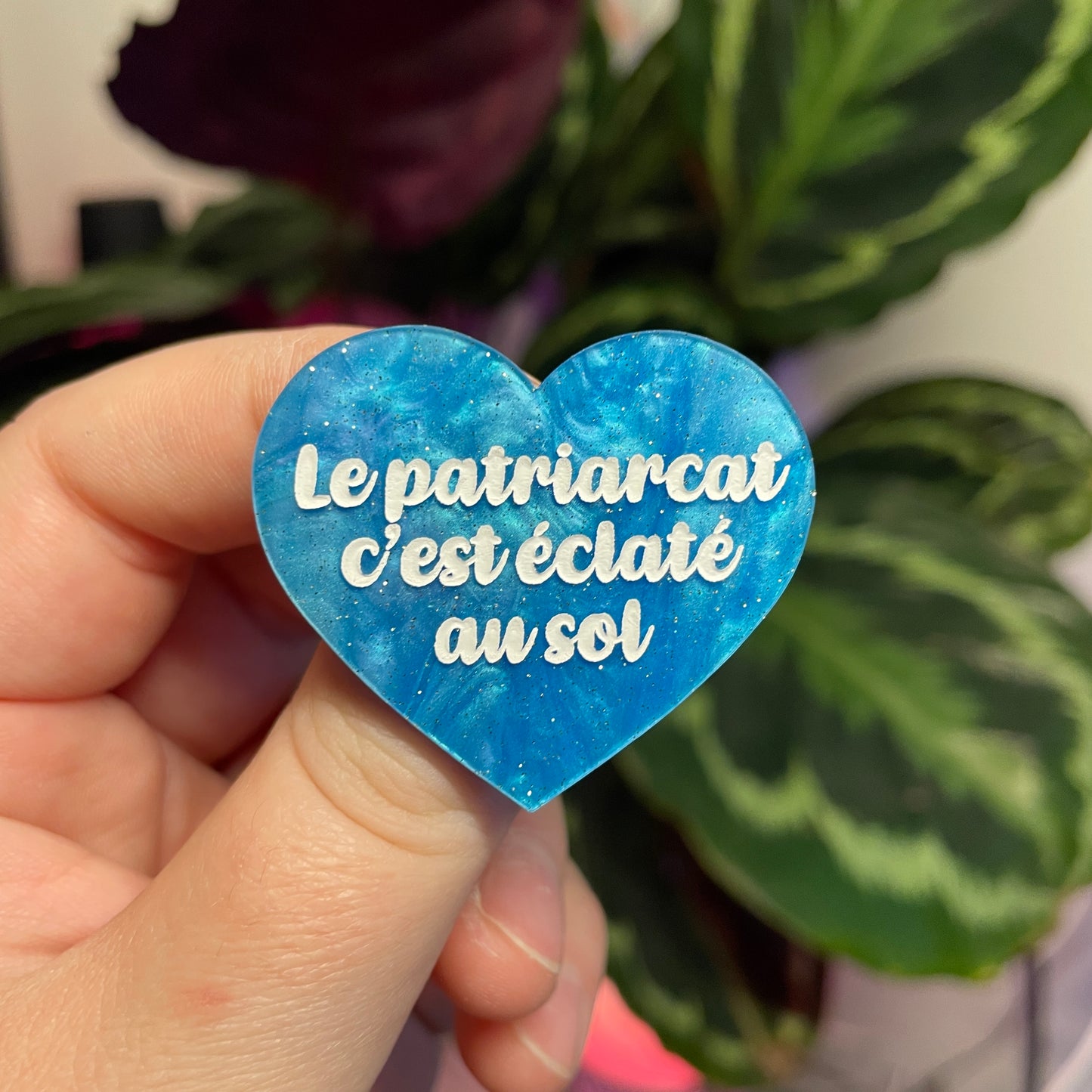 Broche "Le patriarcat c'est éclaté au sol" en acrylique marbrée bleue à paillettes