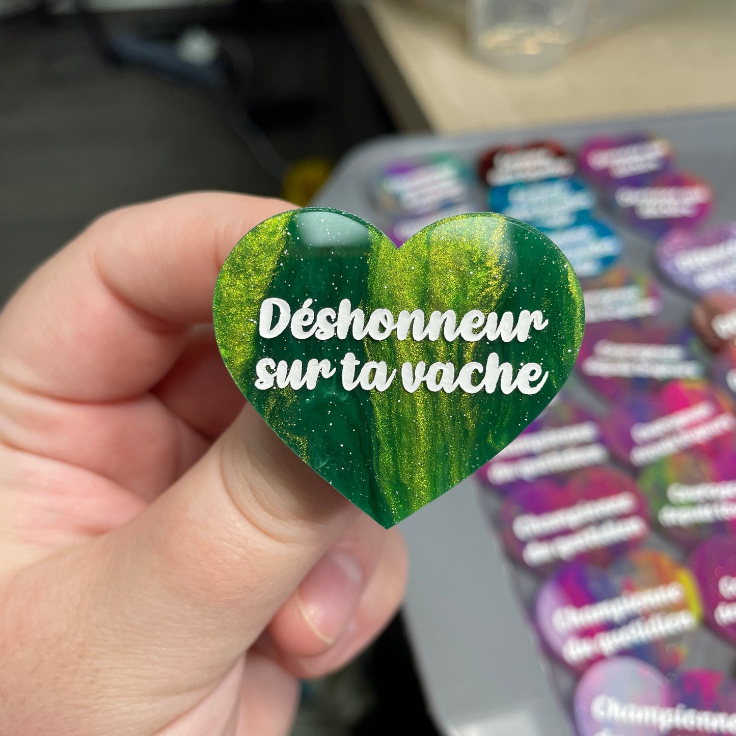 Broche "Déshonneur sur ta vache" en acrylique marbrée verte, dorée et blanche