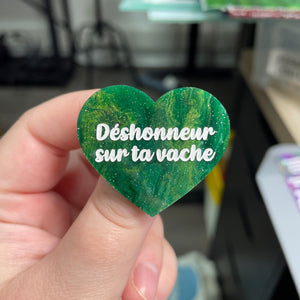 Broche "Déshonneur sur ta vache" en acrylique marbrée verte, dorée et blanche