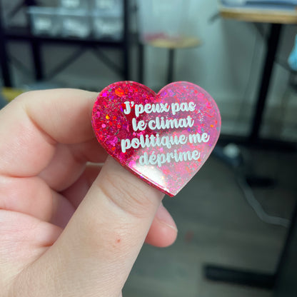 Broche "J'peux pas le climat politique me déprime" en acrylique à paillettes rouges