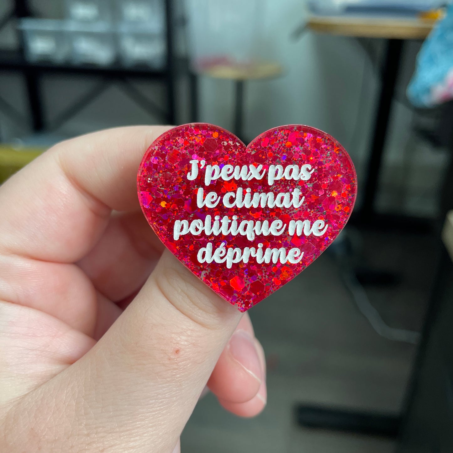 Broche "J'peux pas le climat politique me déprime" en acrylique à paillettes rouges