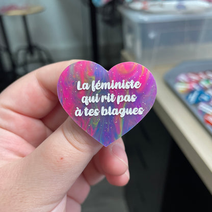 Broche "La féministe qui rit pas à tes blagues" en acrylique semi-transparente marbrée multicolore